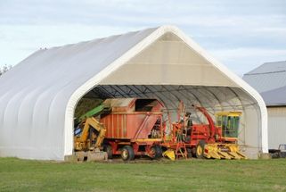 Quonset fabric covered machinery storage building on a farm